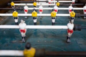 Table football table with yellow and red coloured men to suggest why you must understand your competitors in marketing.