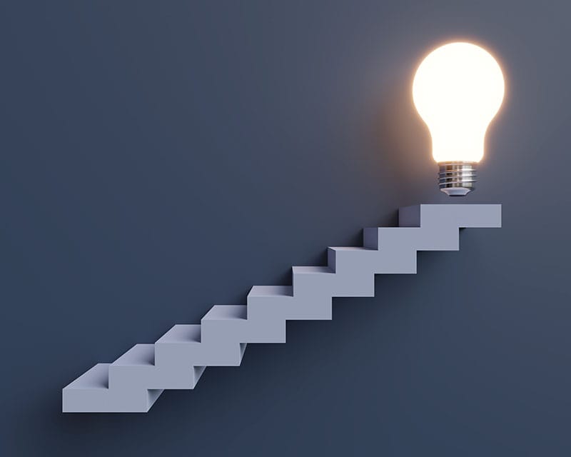 Stairs going up to a lightbulb to show how a small business marketing consultant can help generate new ideas.